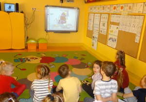Dzieci oglądają prezentację multimedialną o Unii Europejskiej.